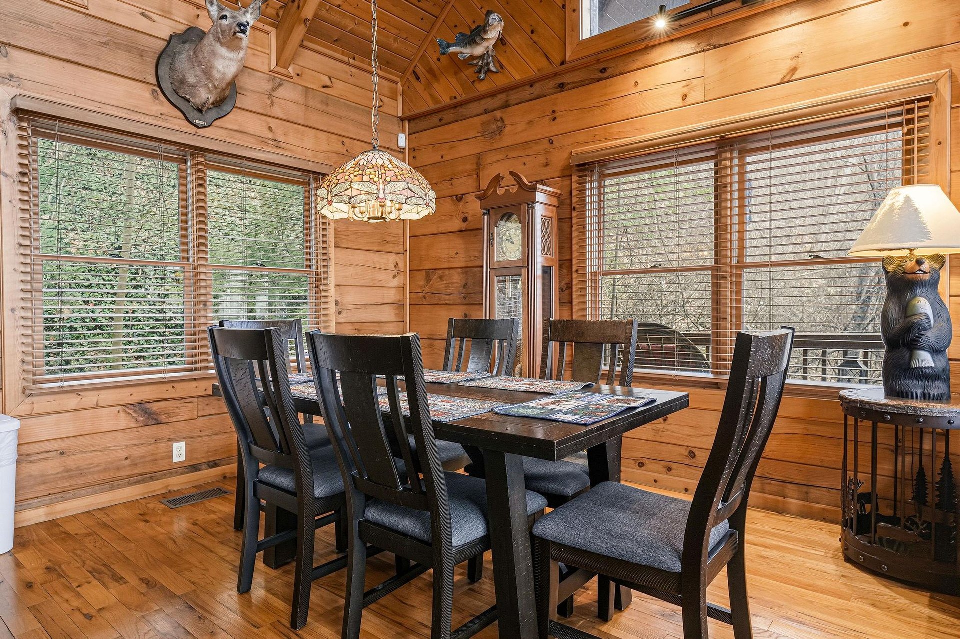 Gather around your private dining table surrounded by warm wood walls and forest views through every window.
