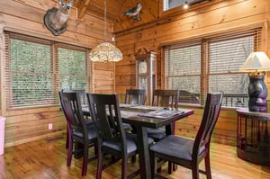 Gather around your private dining table surrounded by warm wood walls and forest views through every window.