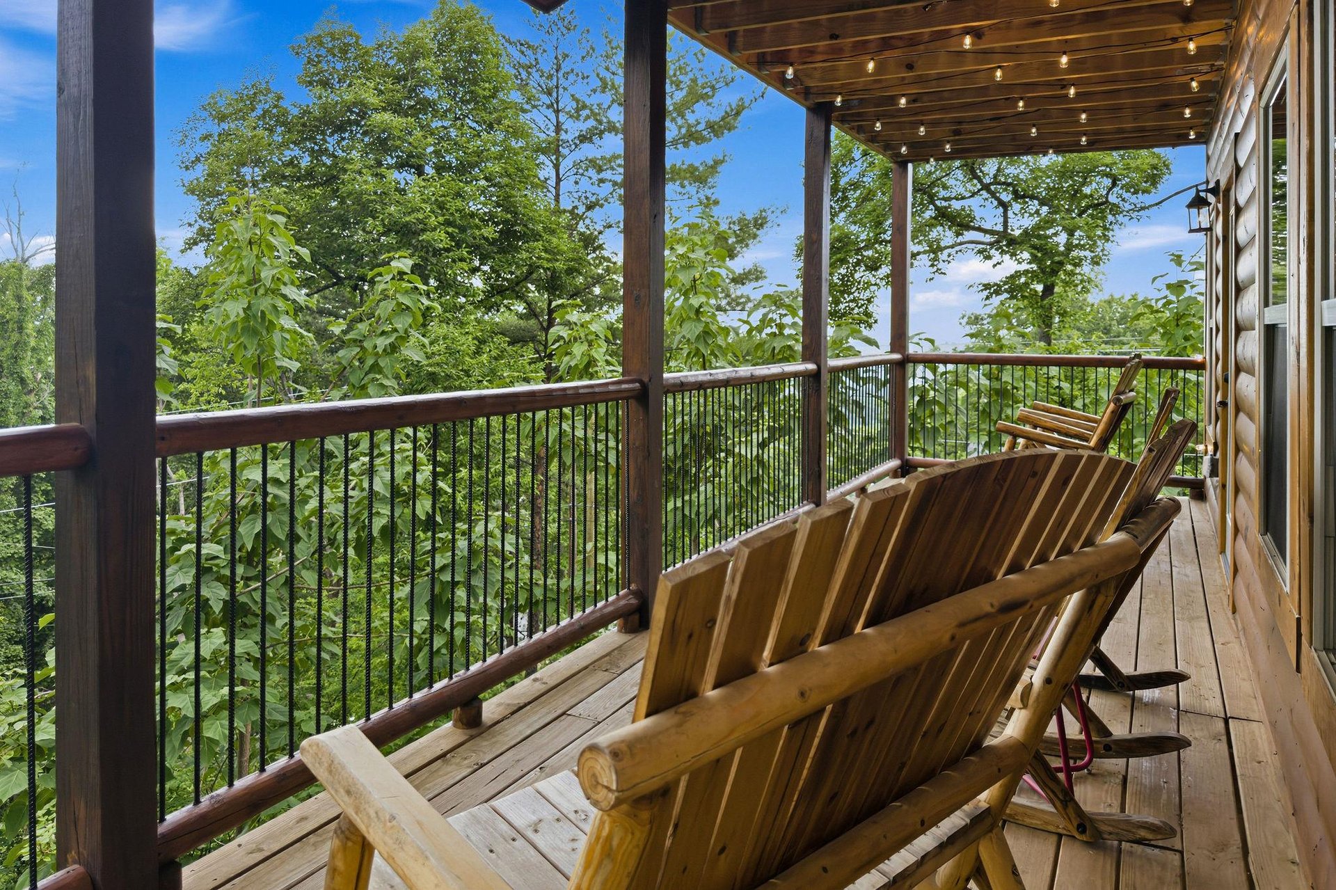 Sink into your private balcony loungers and let the forested views soothe you. String lights overhead set a magical evening mood as nature surrounds your retreat.