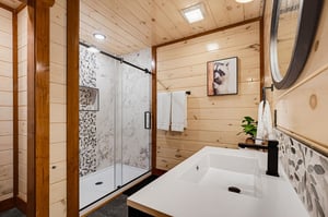 Unwind in your modern bathroom where natural wood warmth meets spainspired luxury, complete with rainfall shower, fresh towels, and artistic touches throughout.