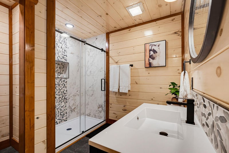 Unwind in your modern bathroom where natural wood warmth meets spainspired luxury, complete with rainfall shower, fresh towels, and artistic touches throughout.
