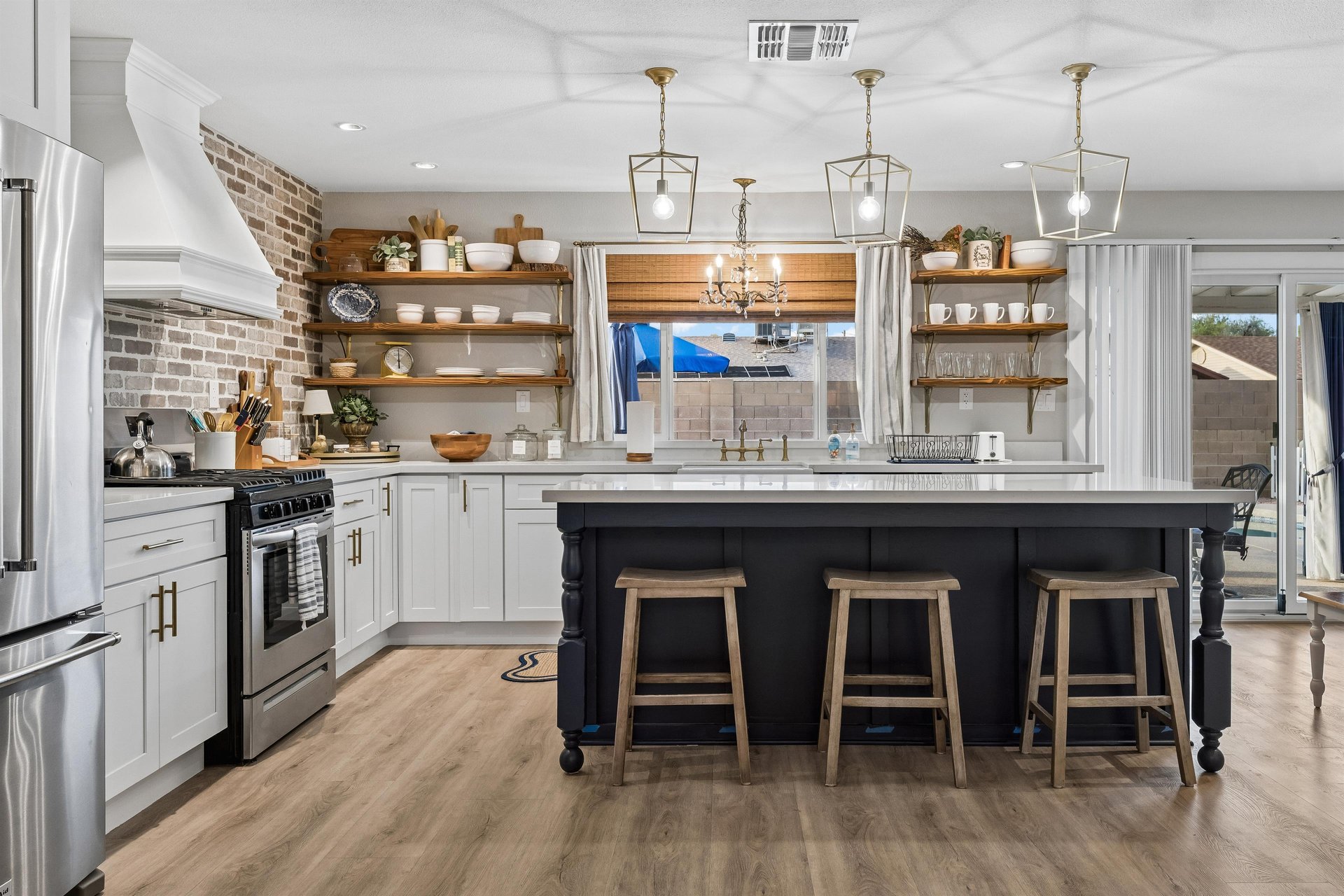 Stainless steel appliances, island counter with seating for 3, and cooking essentials.