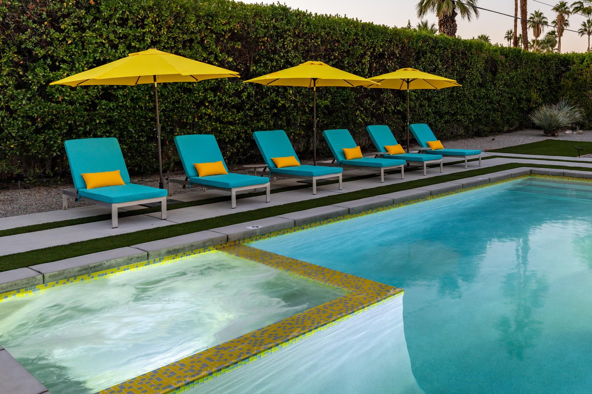 Dive into turquoise waters surrounded by vibrant loungers and sunny umbrellas—your perfect poolside paradise awaits.