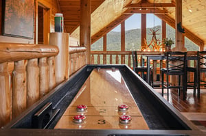 Challenge your travel companions to a friendly game at this sleek shuffleboard table while soaking in stunning mountain views through the floortoceiling windows. The rustic wood beams and cozy seati