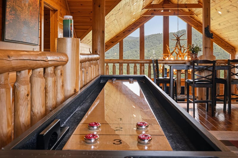 Challenge your travel companions to a friendly game at this sleek shuffleboard table while soaking in stunning mountain views through the floortoceiling windows. The rustic wood beams and cozy seati