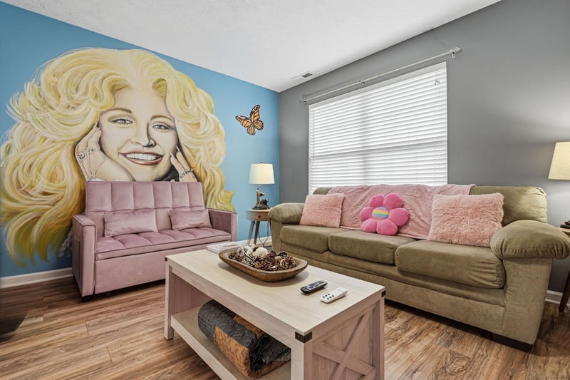 Relax in your vibrant living space featuring a stunning blonde icon mural, cozy seating, and colorful touches that create a playful atmosphere.