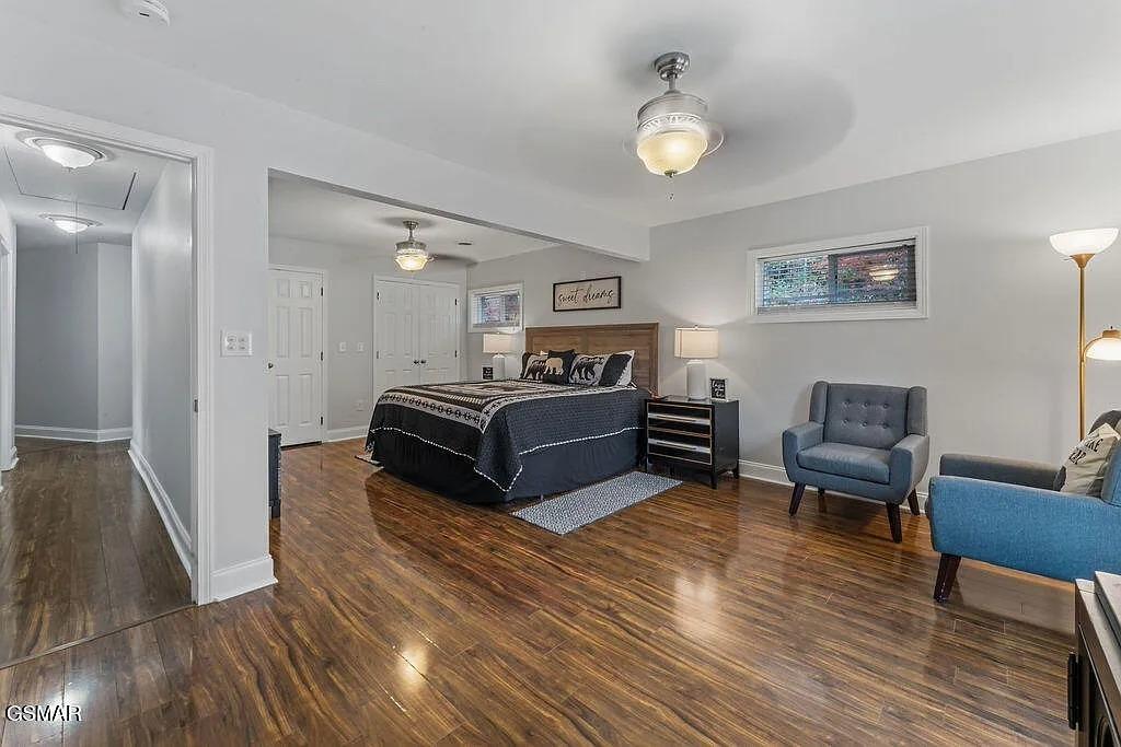 Unwind in your spacious master suite with polished hardwood floors, cozy seating area, and warm ambient lighting creating the perfect retreat.