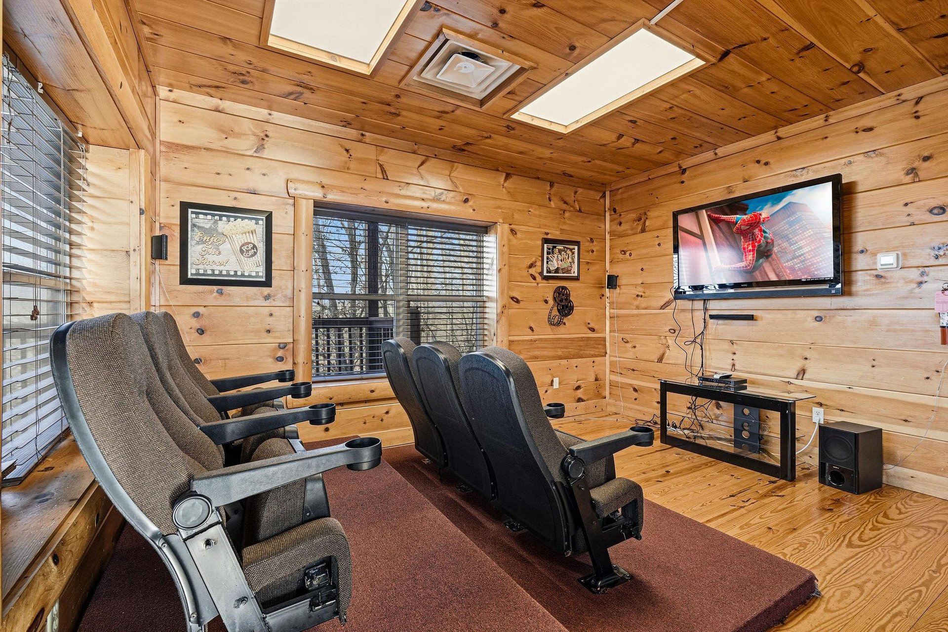 Sink into your private theater chairs and enjoy movie nights in this cozy cabin screening room with surround sound.