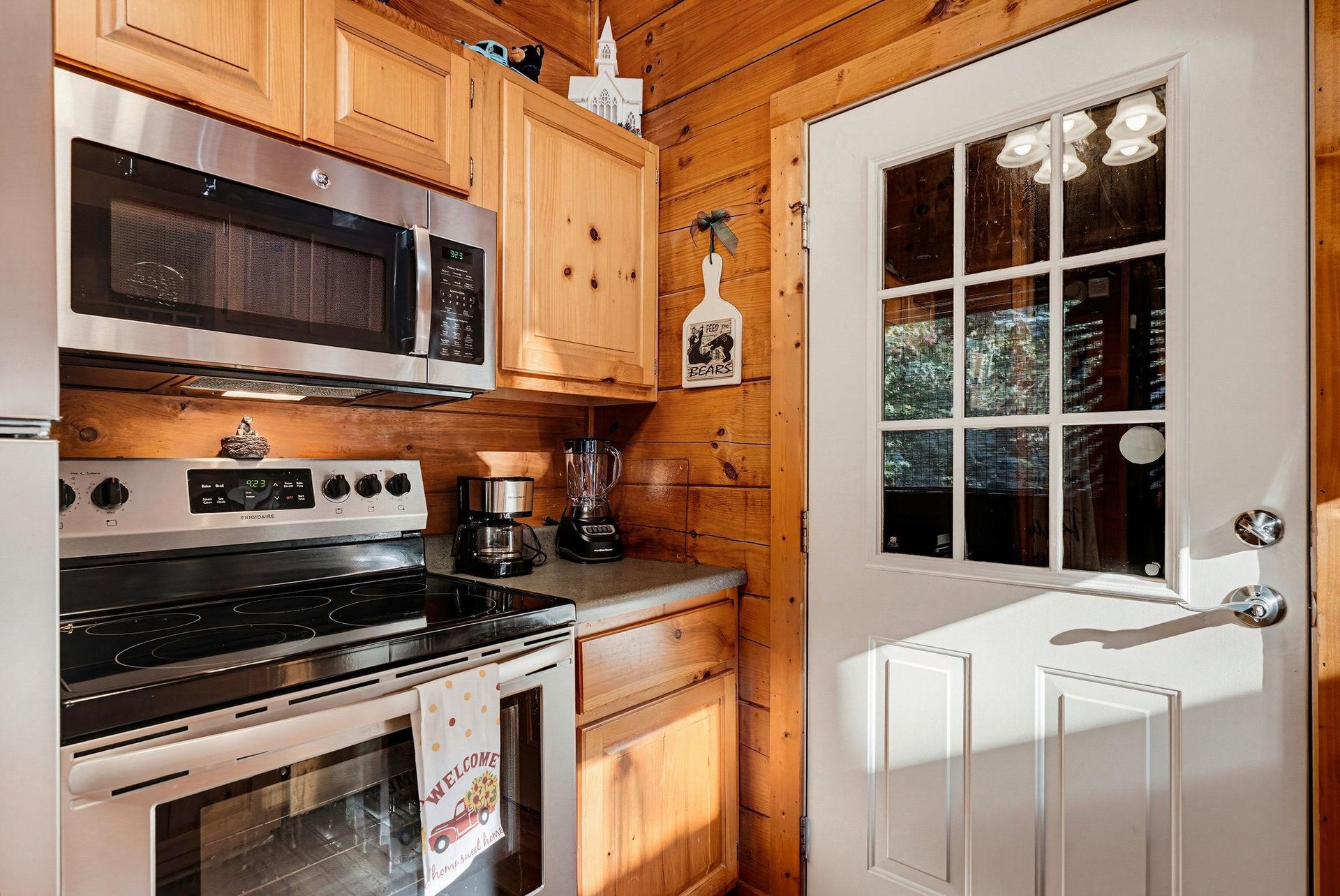 Your fully equipped kitchen awaits with modern appliances and cozy woodpaneled walls, giving you everything you need to whip up meals in a warm, cabinstyle setting.