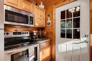 Your fully equipped kitchen awaits with modern appliances and cozy woodpaneled walls, giving you everything you need to whip up meals in a warm, cabinstyle setting.