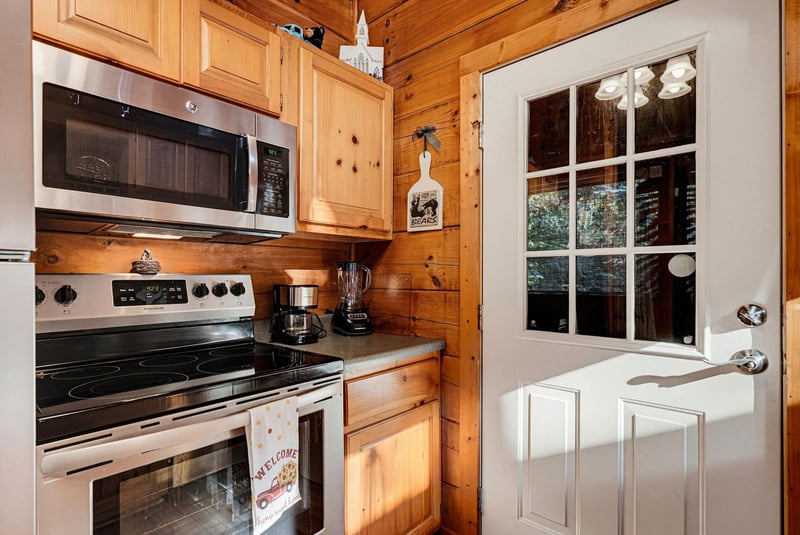 Your fully equipped kitchen awaits with modern appliances and cozy woodpaneled walls, giving you everything you need to whip up meals in a warm, cabinstyle setting.