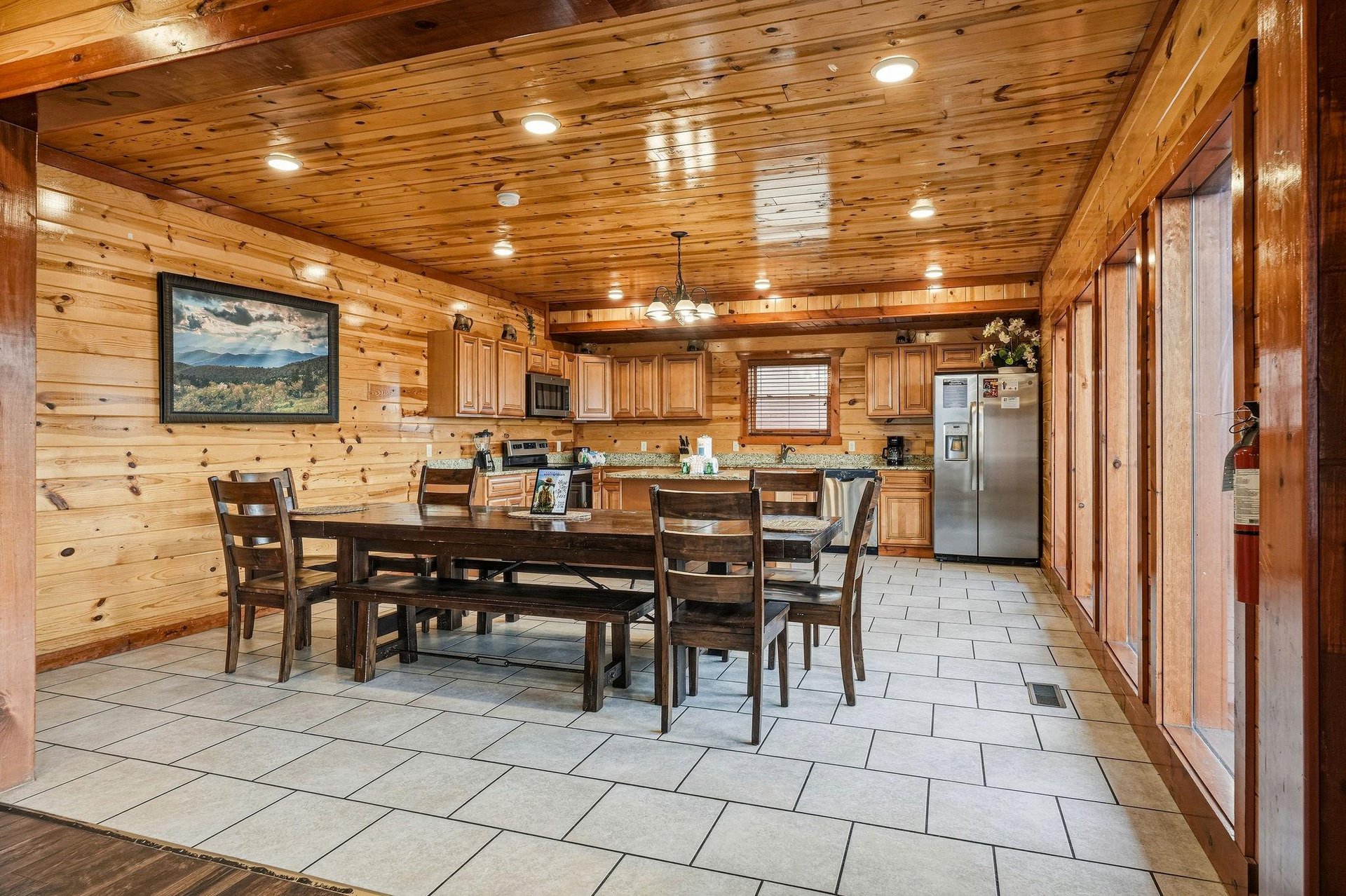 Your spacious cabin kitchen invites family meals with rustic wood beams overhead and a generous dining table perfect for morning coffee together.