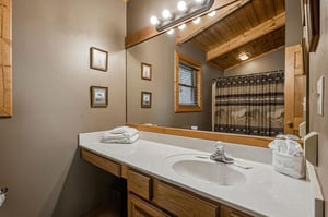 Your private bathroom features rustic wood details, bright vanity lighting, and fresh towels for your comfort.