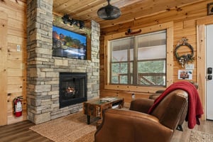 Curl up in your cozy cabin retreat with a crackling fireplace, plush seating, and mountain views framed by natural pine. Your perfect escape for unwinding after adventurefilled days.