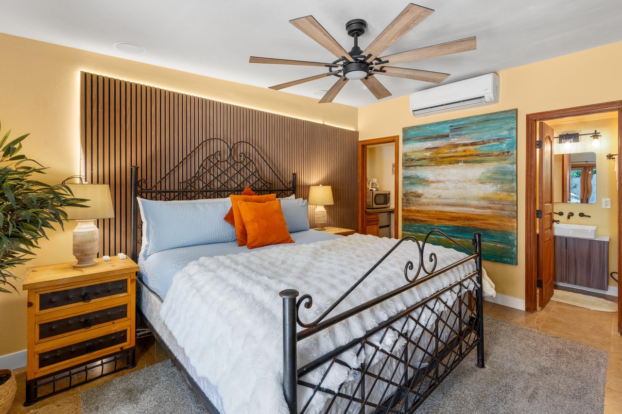 Queen size bed, flatscreen TV, kitchenette, patio access, and ensuite bathroom.
