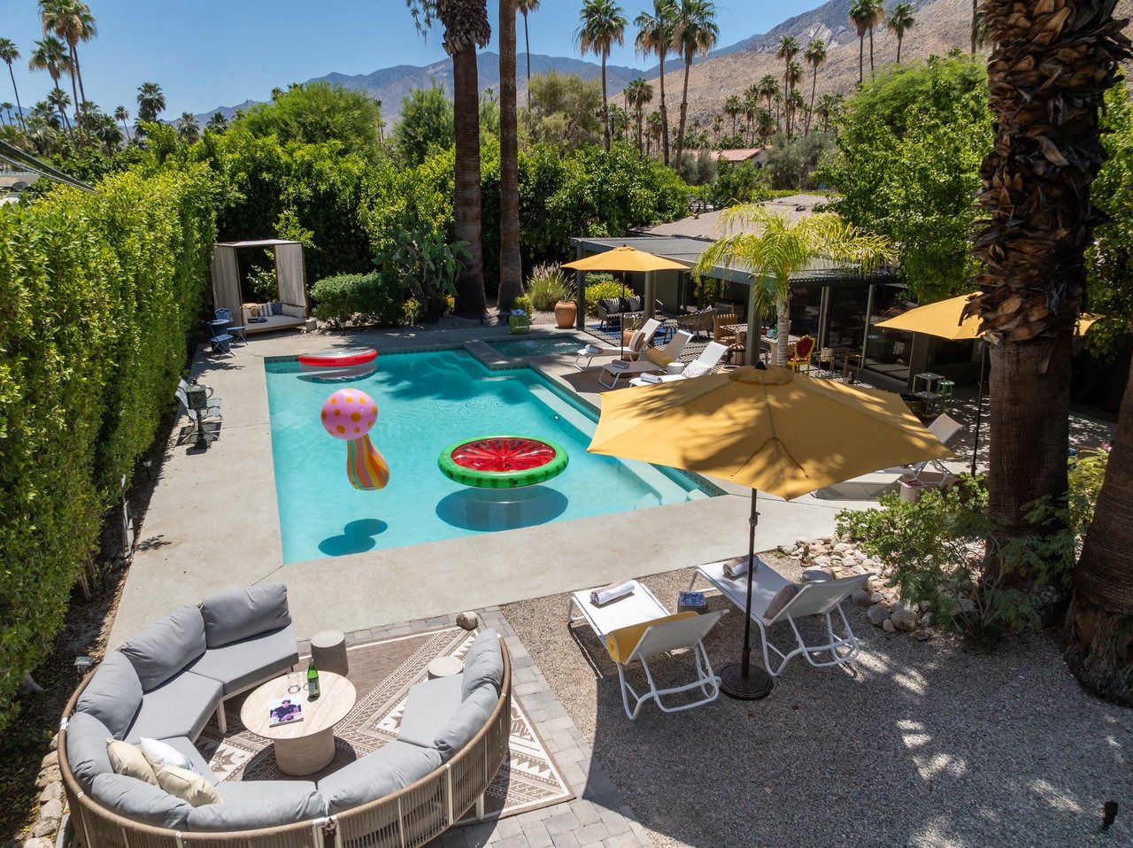 Entertainers backyard with outdoor seating, private pool and spa, sun loungers, cabana, and outdoor dining space.