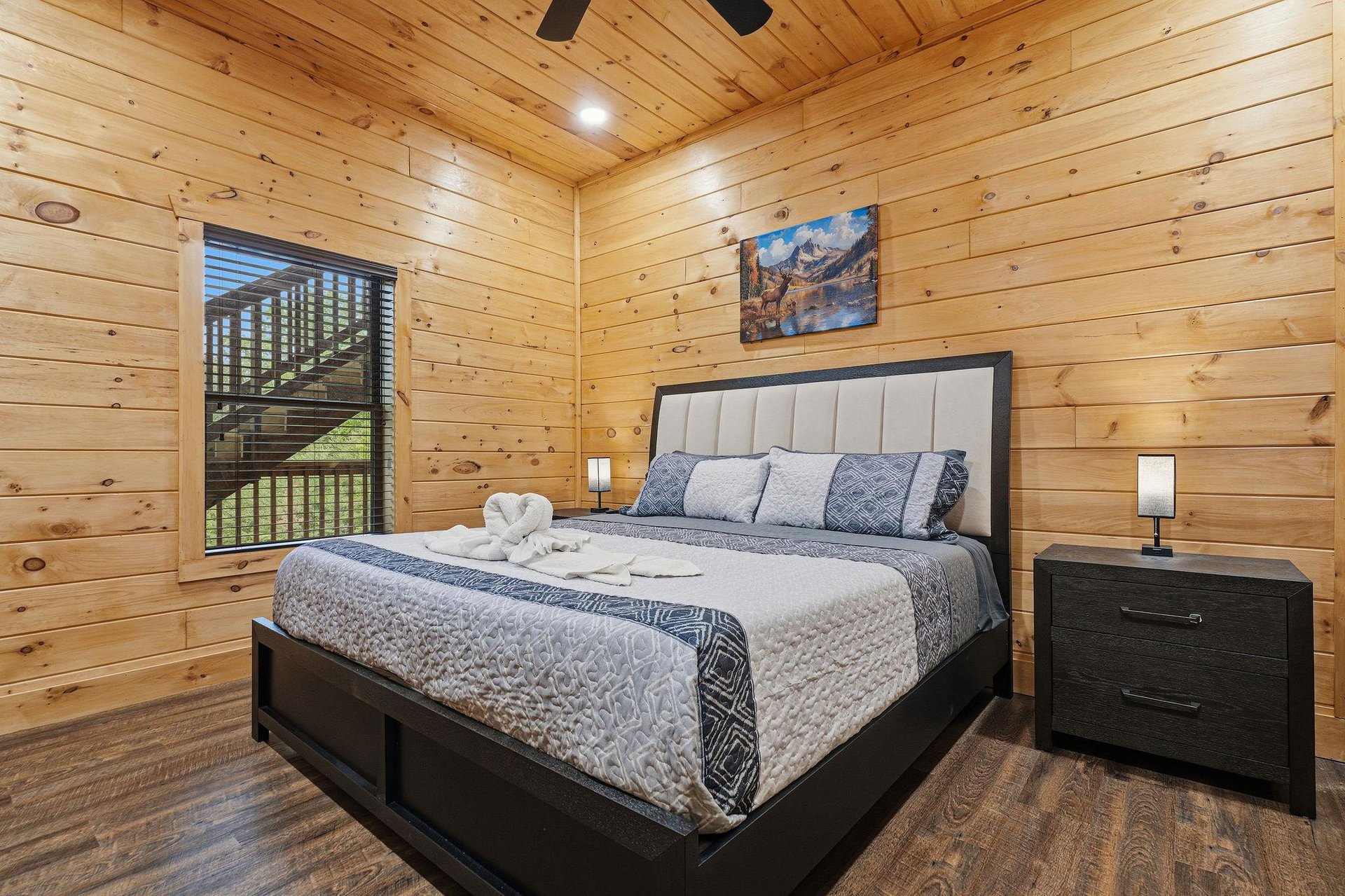Cozy log cabin bedroom with plush bedding and scenic mountain views through your private window.