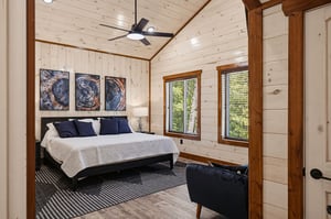 Unwind in your serene bedroom, where vaulted ceilings and warm wood create a cozy retreat. Natural light streams through double windows, inviting peaceful mornings and restful nights in this tranquil 