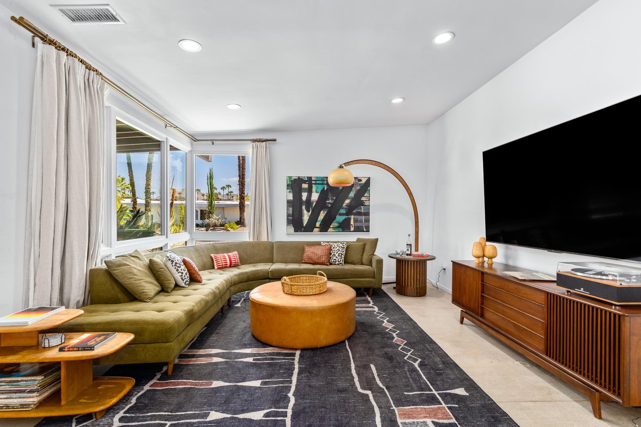 Spacious living room with sectional couch, flatscreen TV, and plenty of natural lighting.