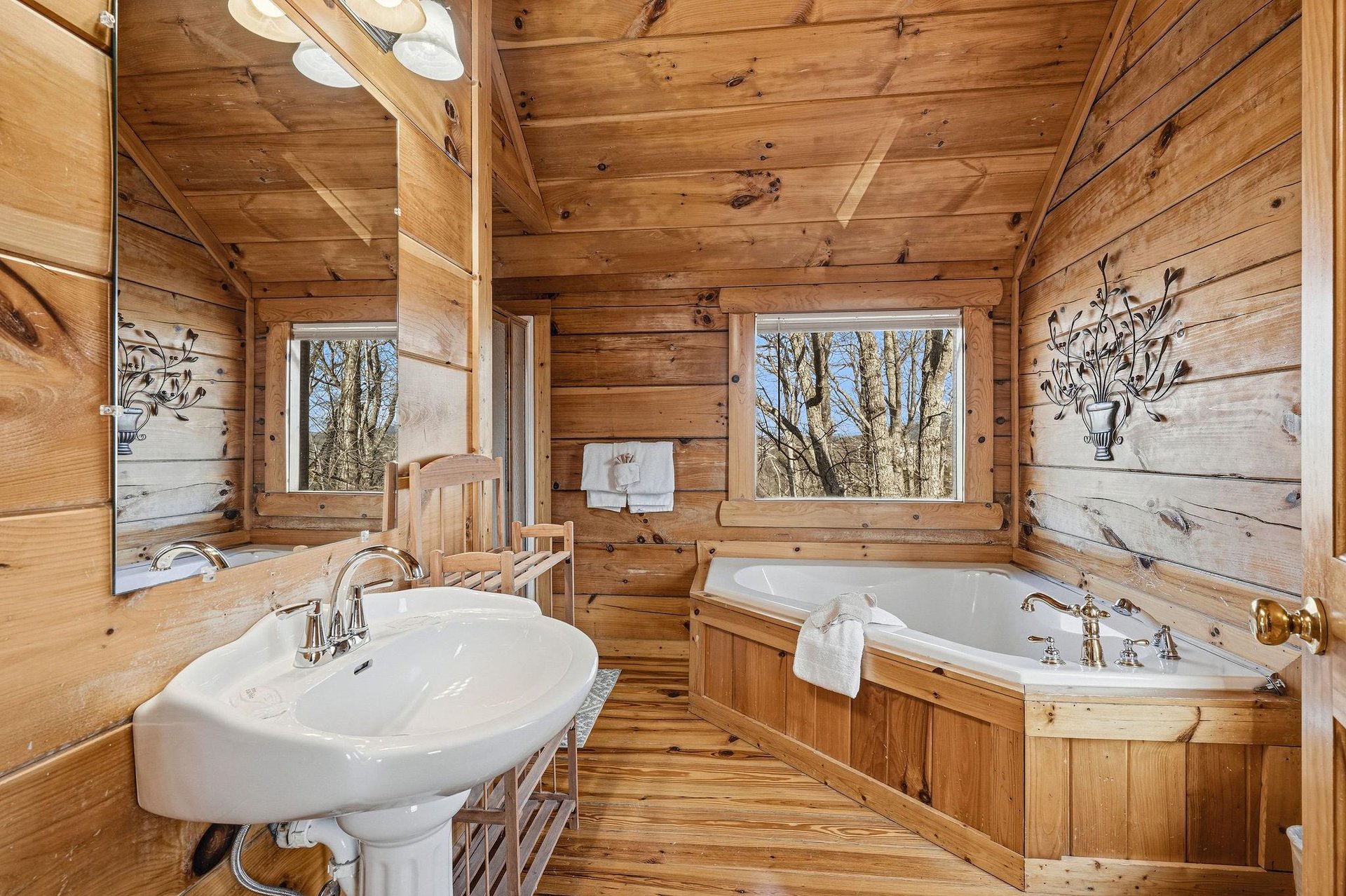 Unwind in your rustic wood bathroom with a soaking tub by the window and charming countryside views.