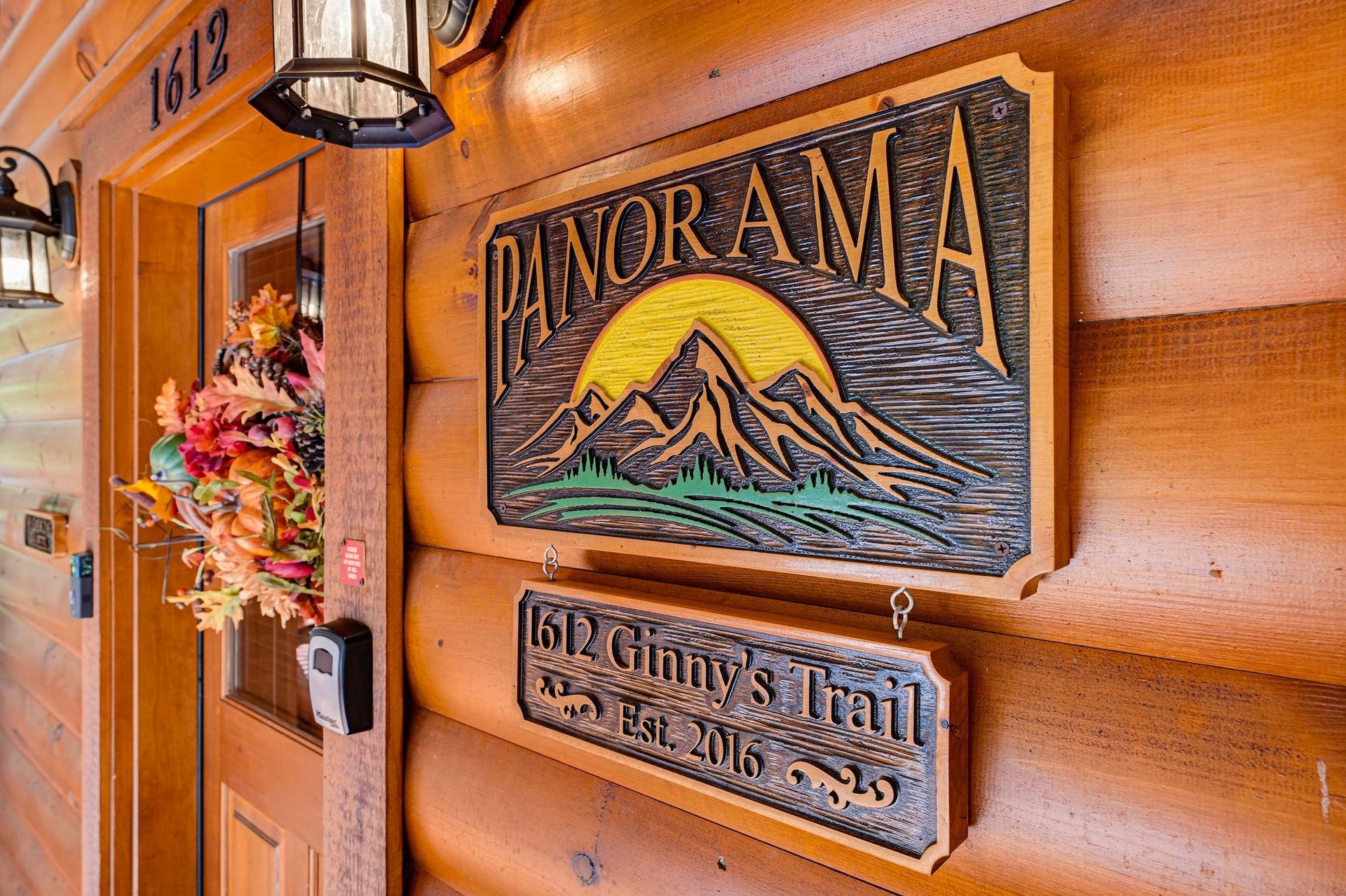 Wooden carved signs mark the entrance to Panorama cabin, nestled on Ginnys Trail with mountaininspired details welcoming guests to this established 2016 retreat.