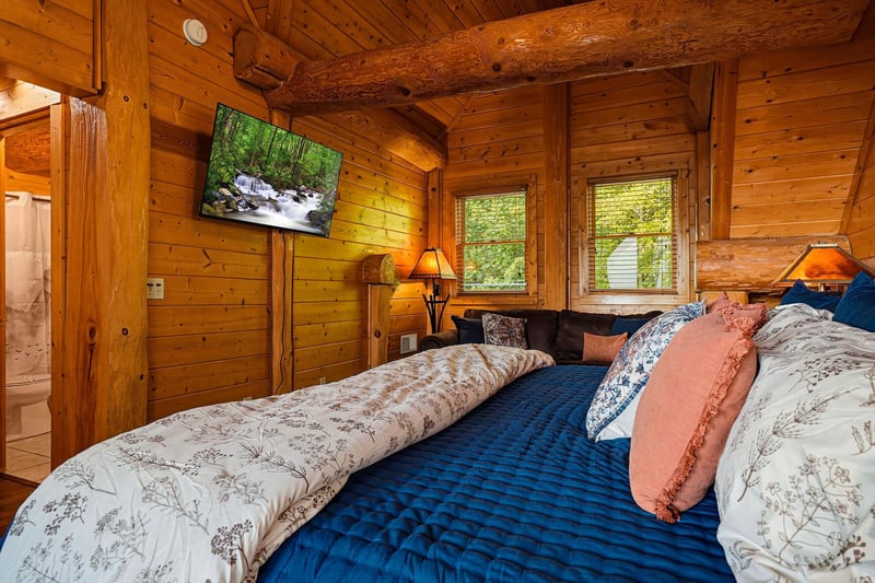 Settle into the warmth of this cozy log bedroom, where natural wood surrounds you and soft light filters through the windows, inviting restful sleep.