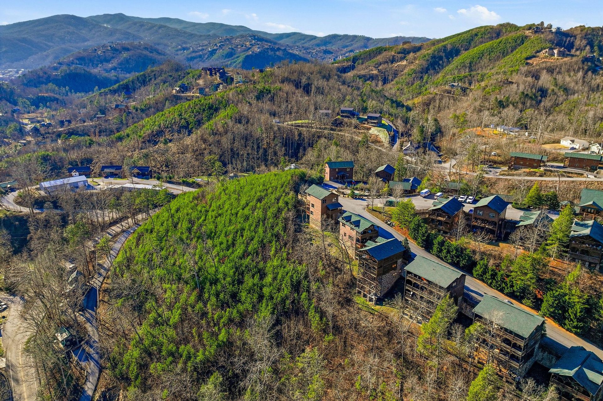 Aerial view of mountain resort community nestled among rolling hills and natural landscape.