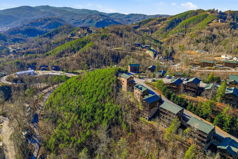 Aerial view of mountain resort community nestled among rolling hills and natural landscape.