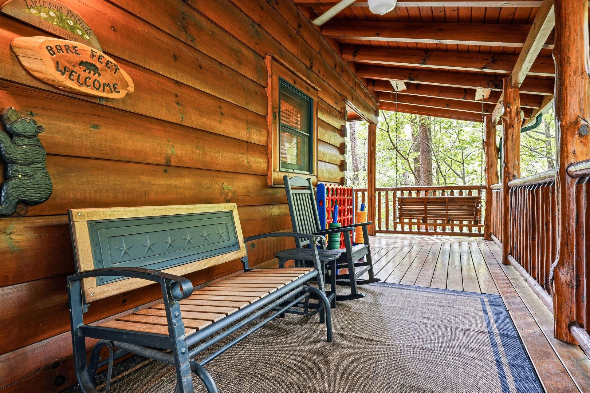 Relax on your private covered porch with rocking chairs and a bench, overlooking peaceful wooded surroundings—perfect for sipping morning coffee or unwinding after a day of adventure.