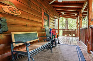 Relax on your private covered porch with rocking chairs and a bench, overlooking peaceful wooded surroundings—perfect for sipping morning coffee or unwinding after a day of adventure.