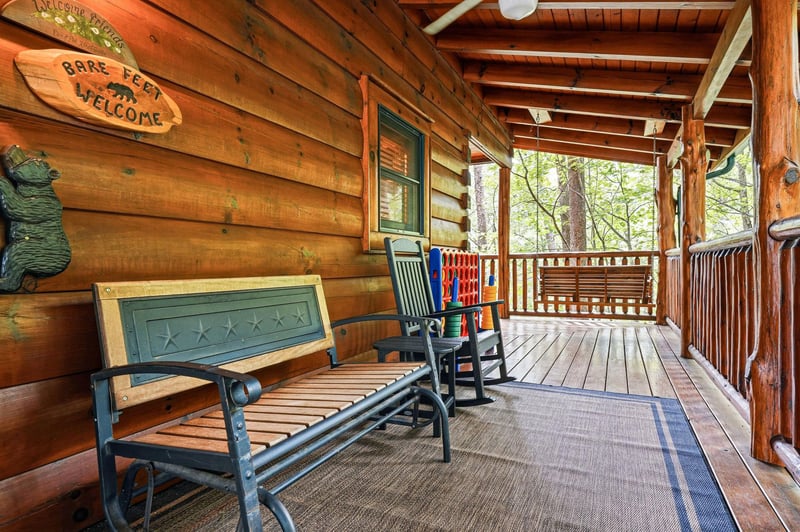 Relax on your private covered porch with rocking chairs and a bench, overlooking peaceful wooded surroundings—perfect for sipping morning coffee or unwinding after a day of adventure.