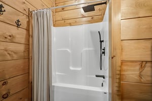 Rustic charm meets modern comfort in your private bathroom, where natural wood walls create a cozy cabin atmosphere around your pristine shower.