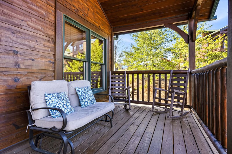 Unwind on your private covered deck with comfortable seating and peaceful mountain views framed by spring greenery.