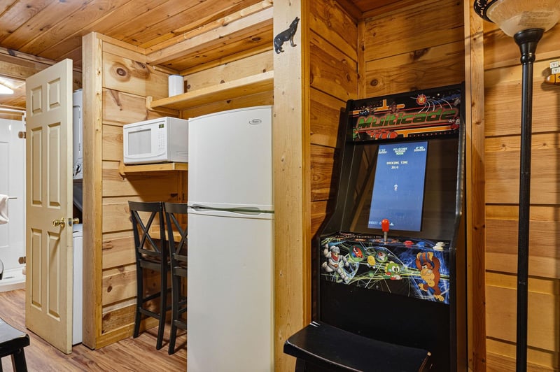 Step into your cozy cabin retreat with a fullyequipped kitchen and a classic arcade game for funfilled evenings. Warm wood paneling and thoughtful details make this space uniquely yours.