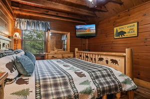 Slip into your cozy cabin bedroom under warm quilts and rustic timber beams. Your woodland getaway feels like a hug, with charming bearthemed touches welcoming you home.