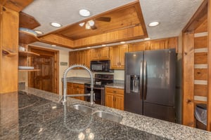 Kitchen with black appliances at Cubs Crib, a 3 bedroom cabin rental located in Gatlinburg