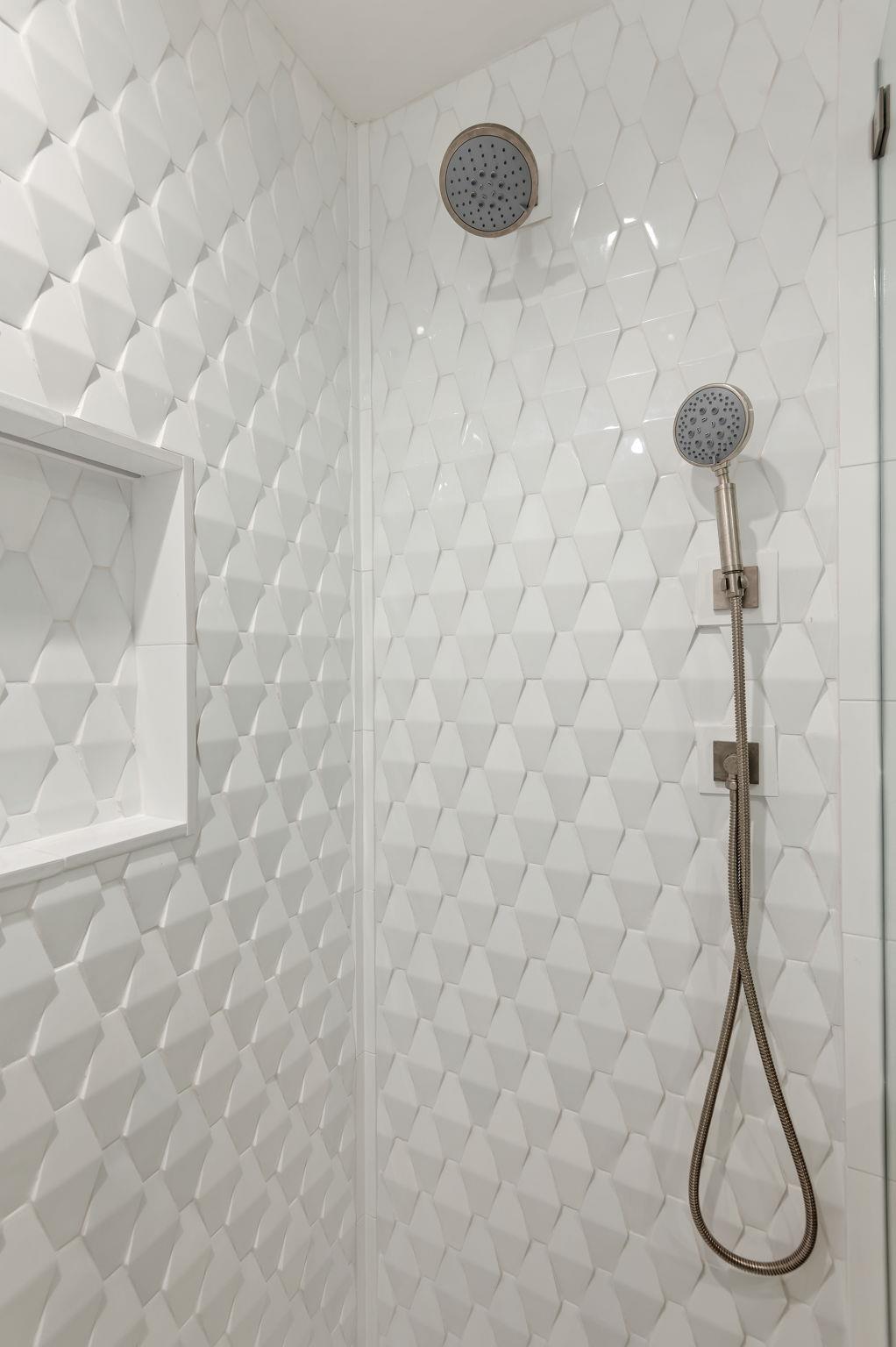 Walkin shower with two shower heads.