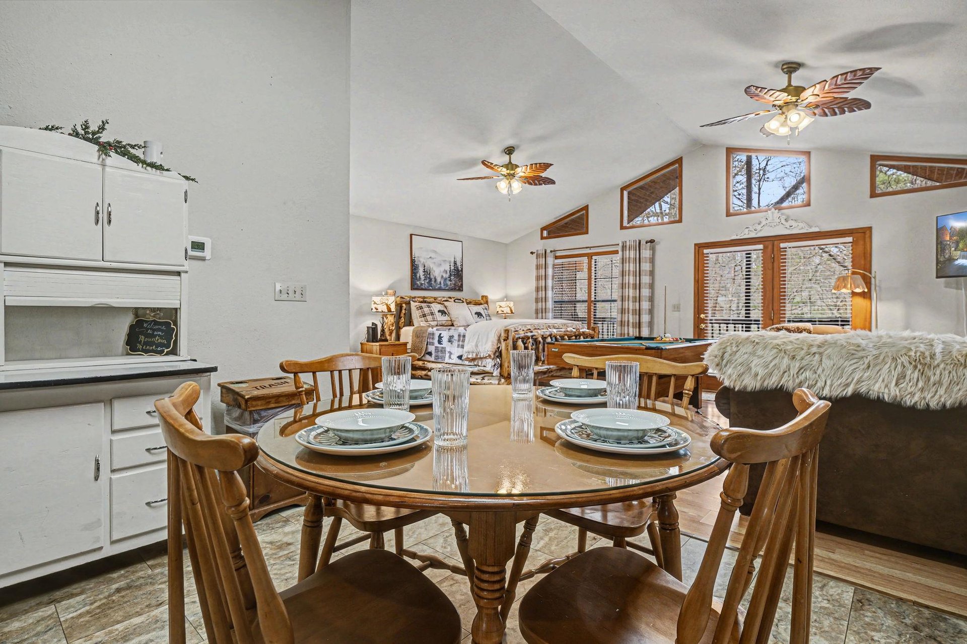 Gather around your warm wooden dining table while cozy ceiling fans circulate the air above your fullyequipped kitchen and plush living space.
