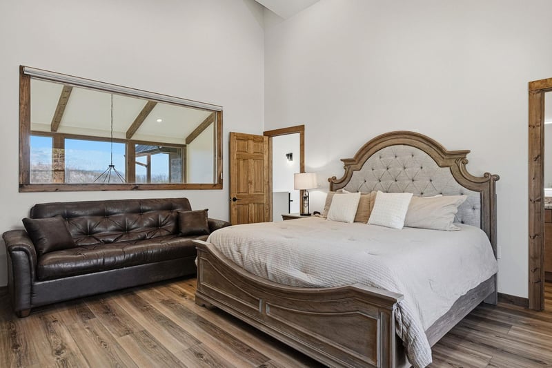 Sink into luxury with this elegant bedroom featuring a plush king bed and cozy leather seating area for your perfect retreat.