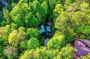 Aerial view of a secluded property nestled among vibrant forest canopy, offering complete privacy and natural surroundings.