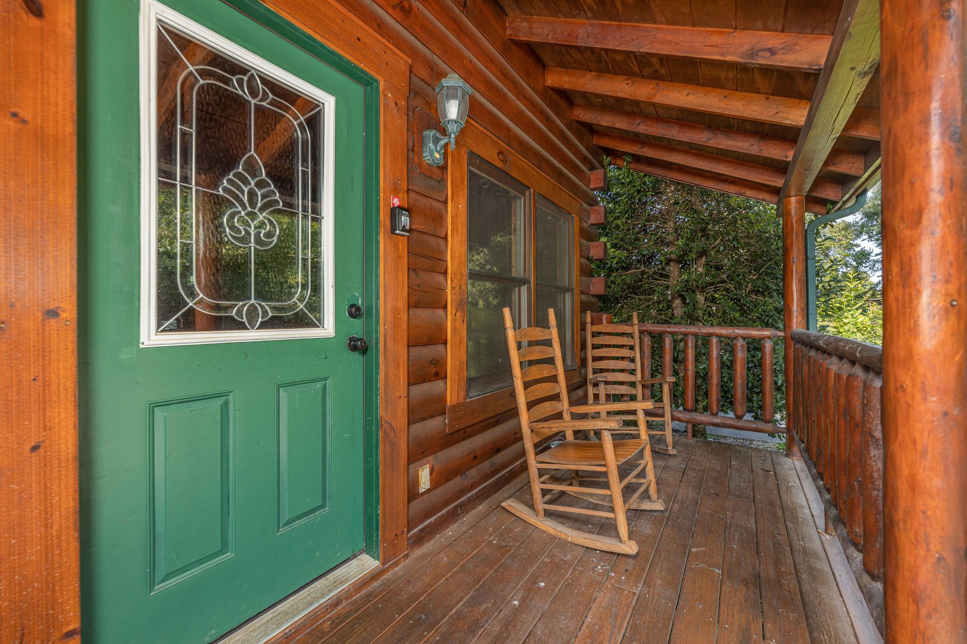 Green front door with deck rocking chairs