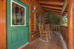 Green front door with deck rocking chairs