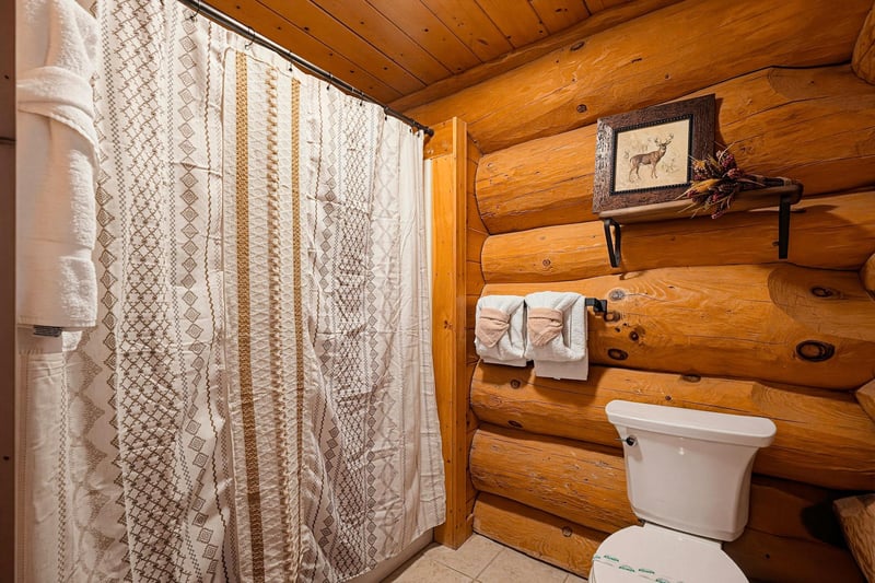 Your rustic bathroom features warm log cabin walls and thoughtfully arranged towels to make you feel right at home after a day of exploring.