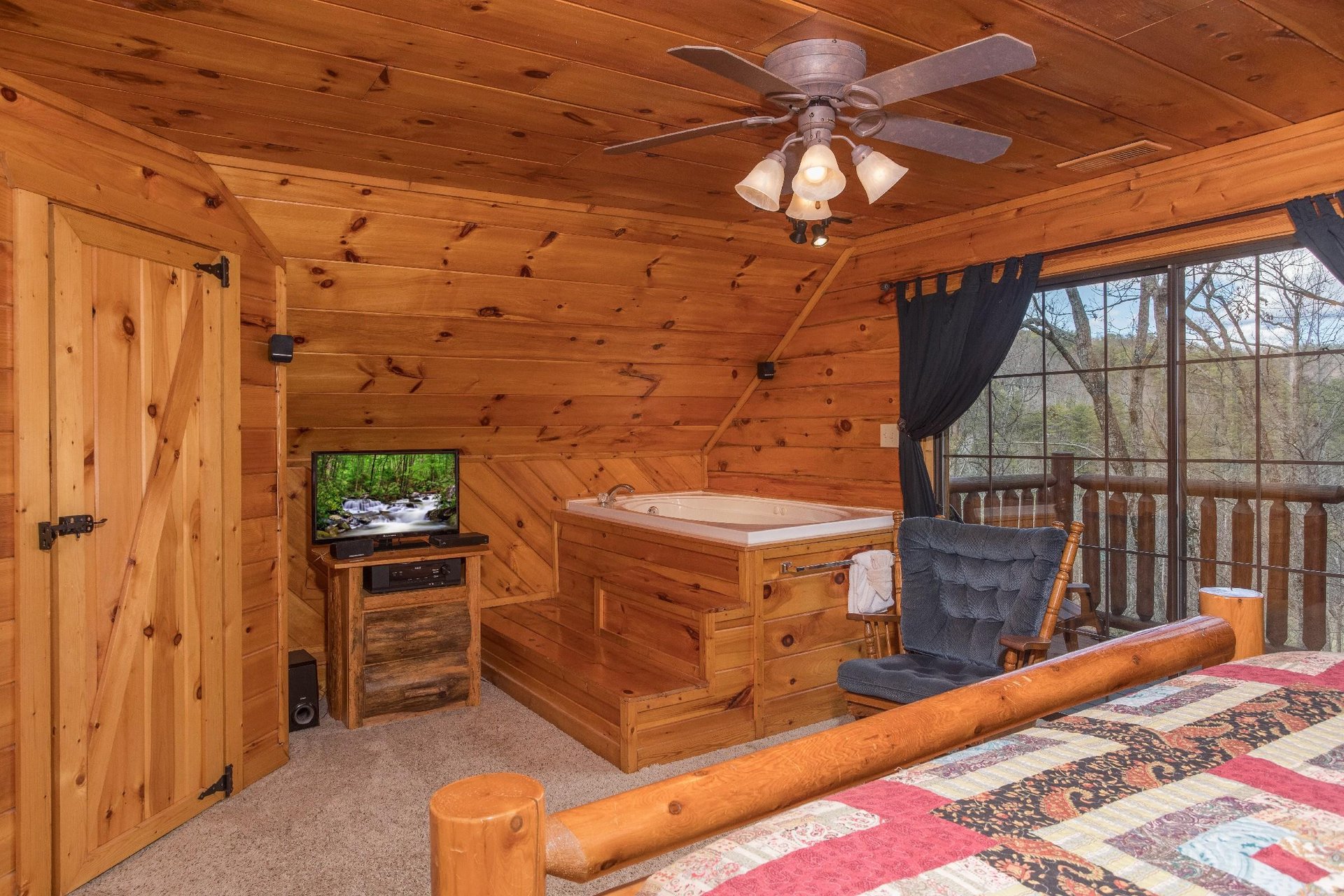 Bedroom with private deck access, in room jacuzzi, and TV at Hidden Pleasure, a 1bedroom cabin rental located in Gatlinburg