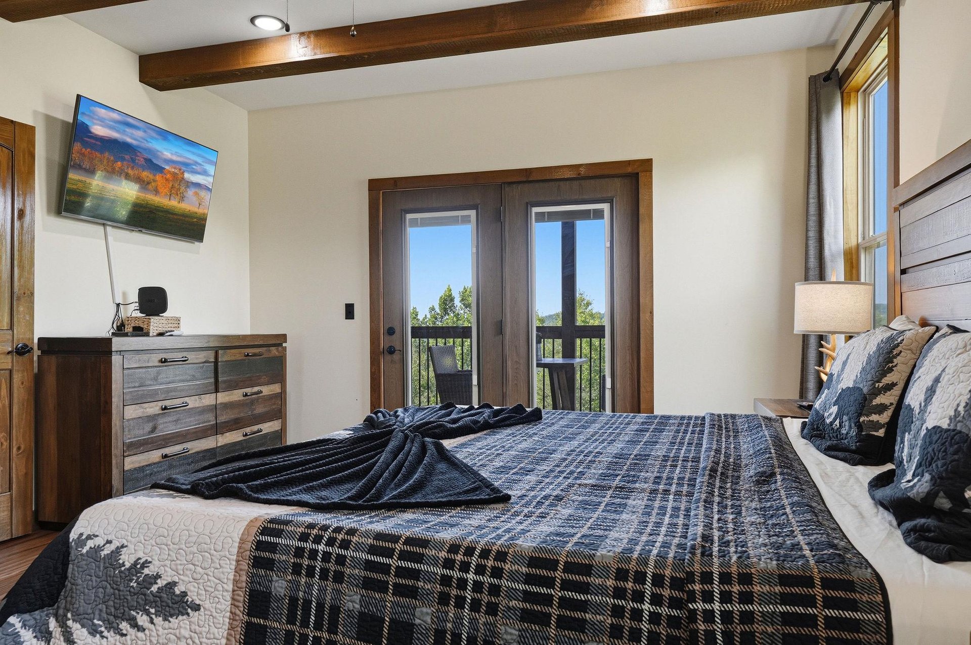 Wake up to natural light and direct access to your private balcony, where peaceful greenery awaits. The rustic wood beams and cozy linens create a serene retreat after a day exploring the area.