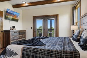 Wake up to natural light and direct access to your private balcony, where peaceful greenery awaits. The rustic wood beams and cozy linens create a serene retreat after a day exploring the area.