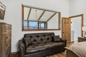 Relax on your private leather sofa while enjoying mountain views through the rustic window frame.