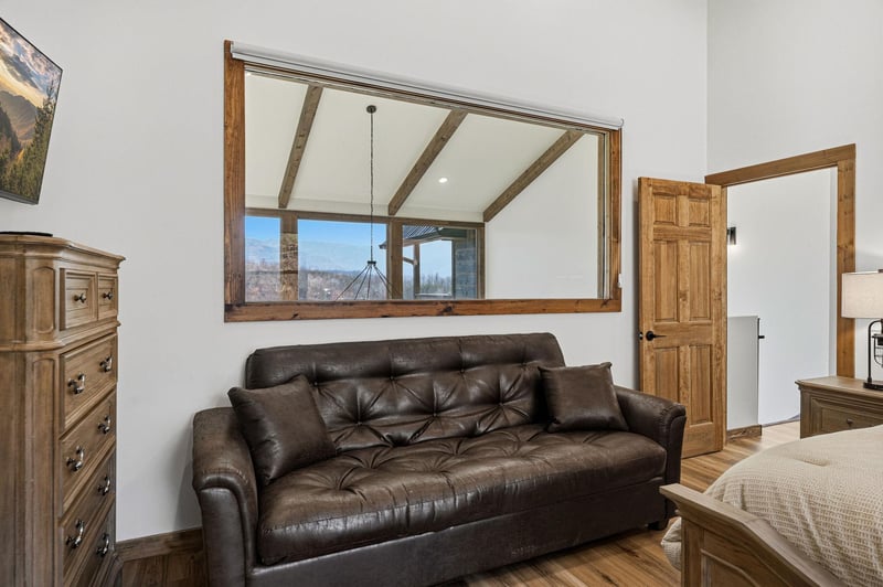 Relax on your private leather sofa while enjoying mountain views through the rustic window frame.