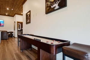 Challenge friends to a friendly game at your private shuffleboard table, complete with cozy seating and warm wood accents overhead.