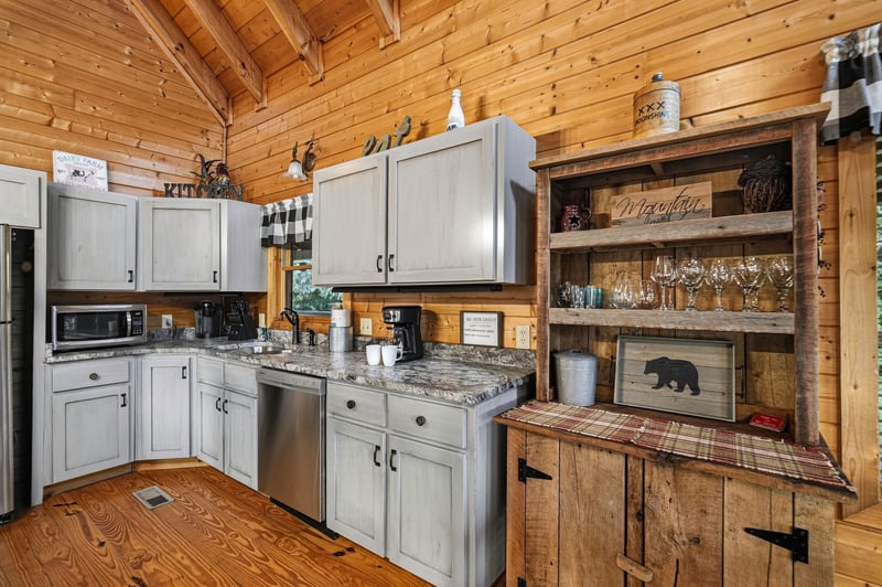 Step into your inviting mountain cabin kitchen, where rustic wood charm meets modern convenience. The vaulted pine ceiling and cozy décor create a warm retreat for cooking and gathering.